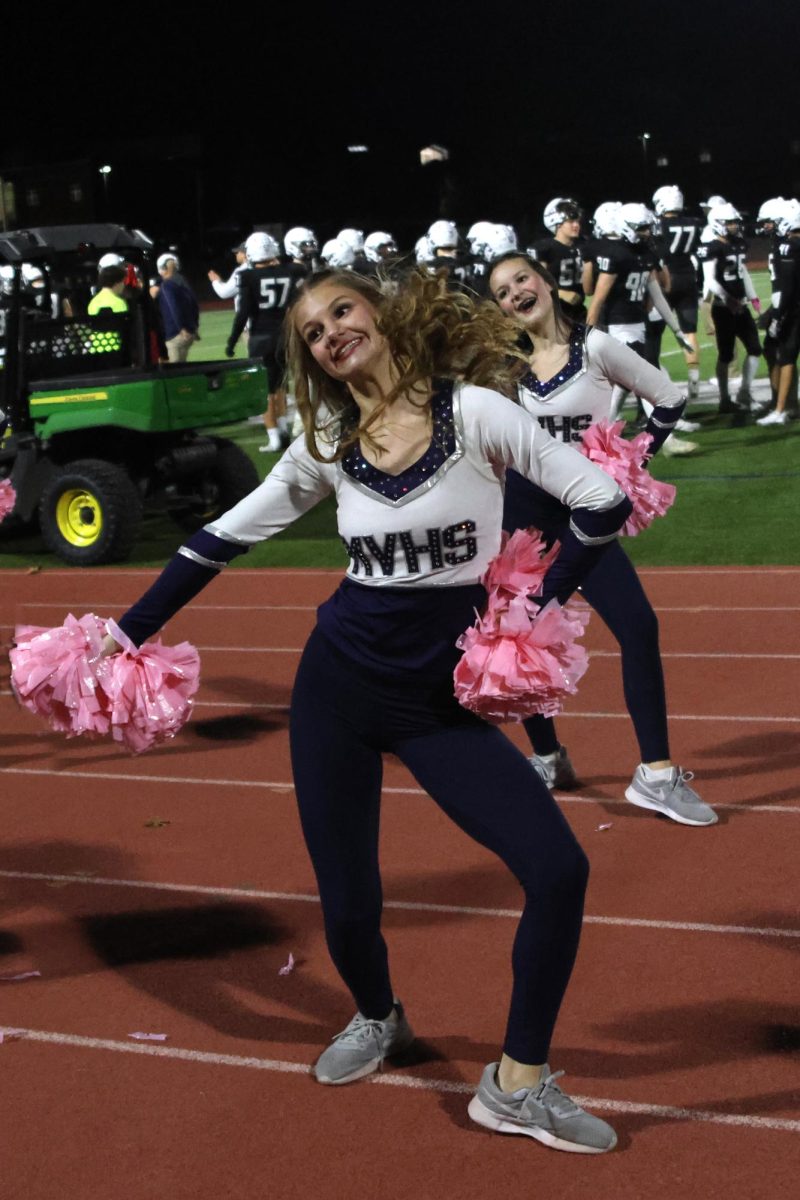 Junior Ella Jones performs on the sidelines of the Mill Valley football field to get the fans on their feet in support of the Jaguars.