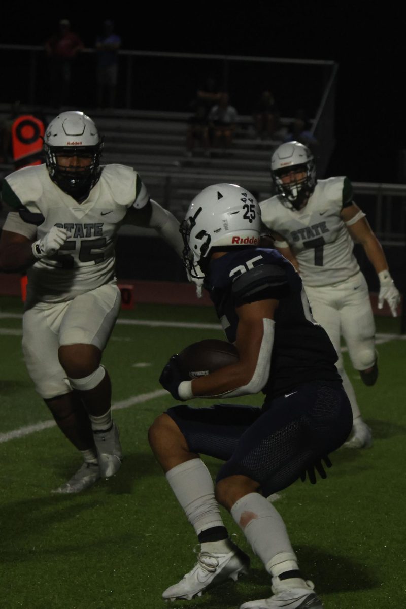 Eluding a tackle from the opposing team, junior Reggie Reece runs towards the end zone, ball in hand.