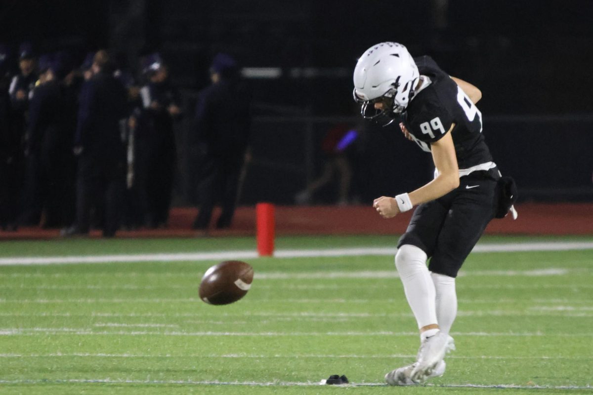 After a scored touchdown, senior Aiden Standley kicks the ball to lock down another point.