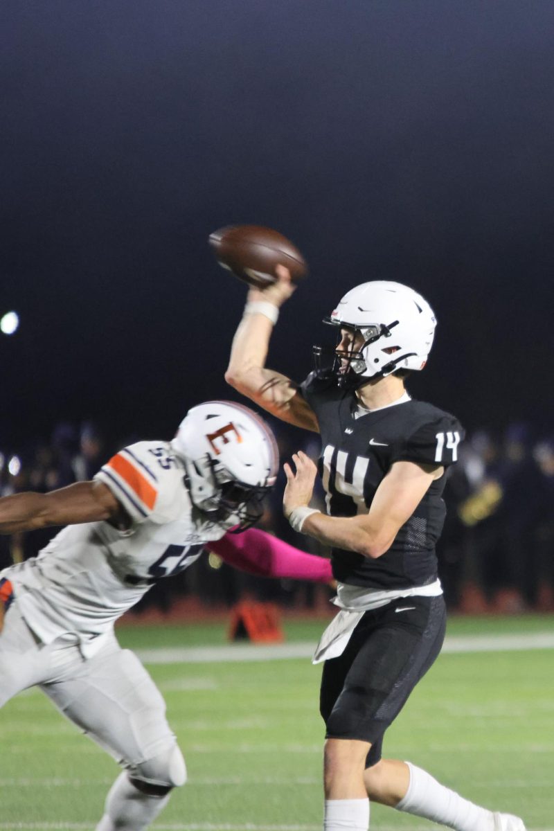 While facing a tackle, senior Connor Bohon passes the ball to a teammate.