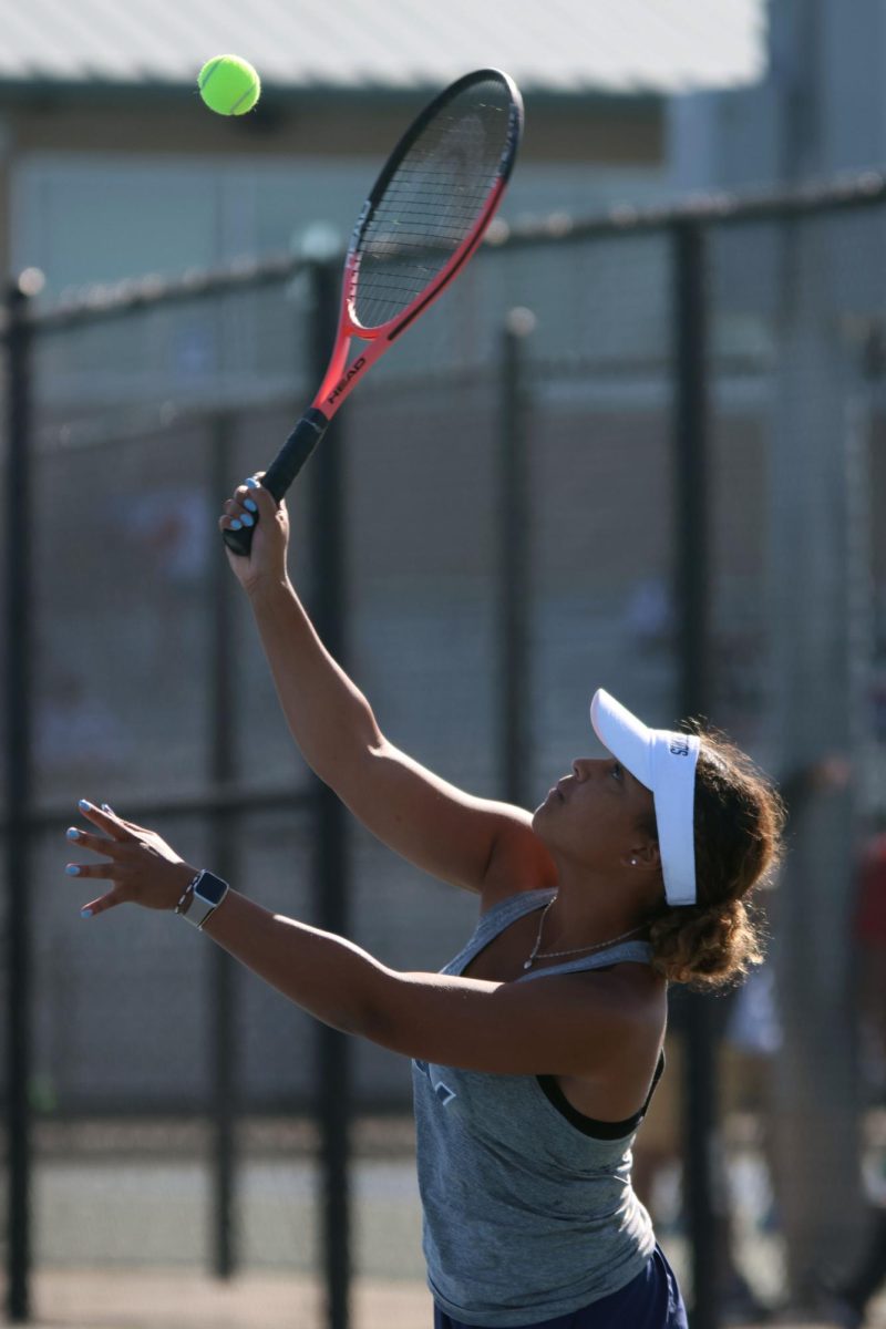 To begin the point, senior Kyra Nelson serves the ball. 