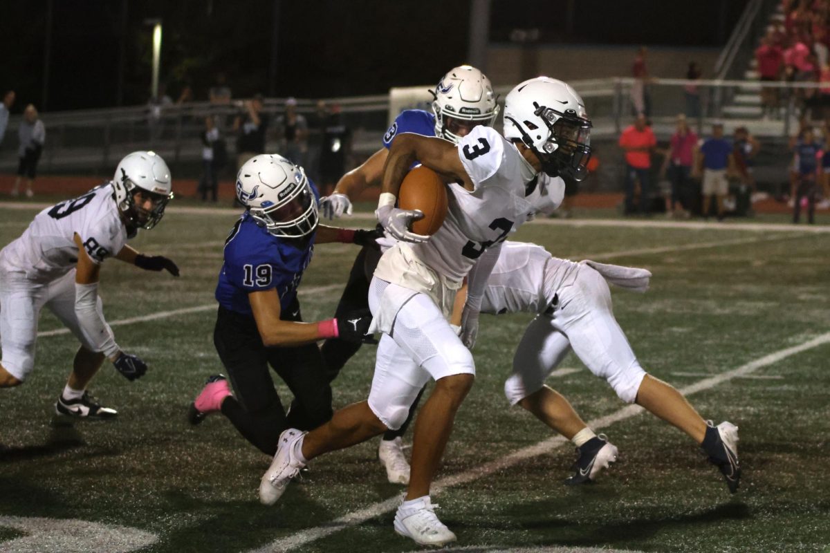 With the ball in his right arm, senior Desmon Williams runs toward the end zone.