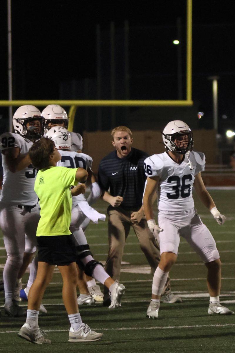 Celebrating the teams' first down, Coach ... gets them ready to play.