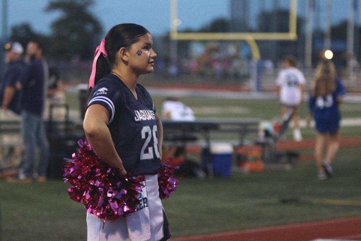 With her hands on her hips, Junior Ava Lucht looks into the crowd.