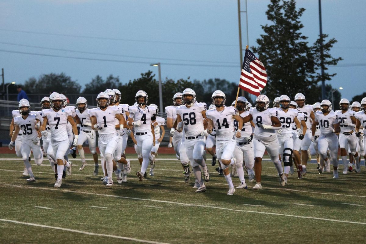 The Mill Valley football team runs onto the field at their game against Gardner Edgerton.