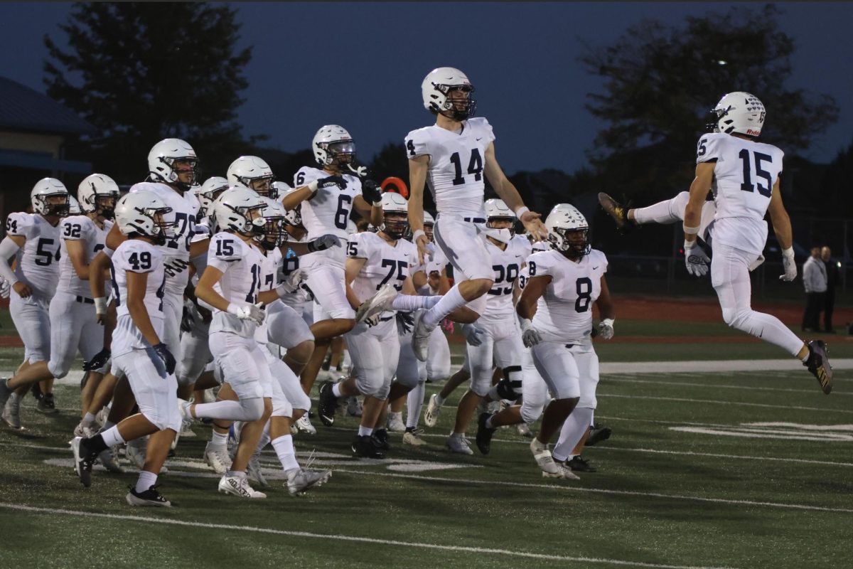 Seniors Connor Bohon and Andrew Watts leap into the air to celebrate the coin toss.