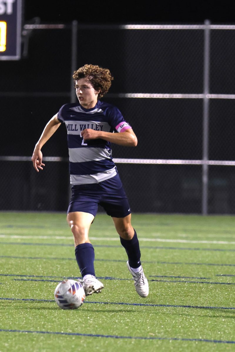 Looking ahead, Junior Landon Vincent kicks the ball up field.