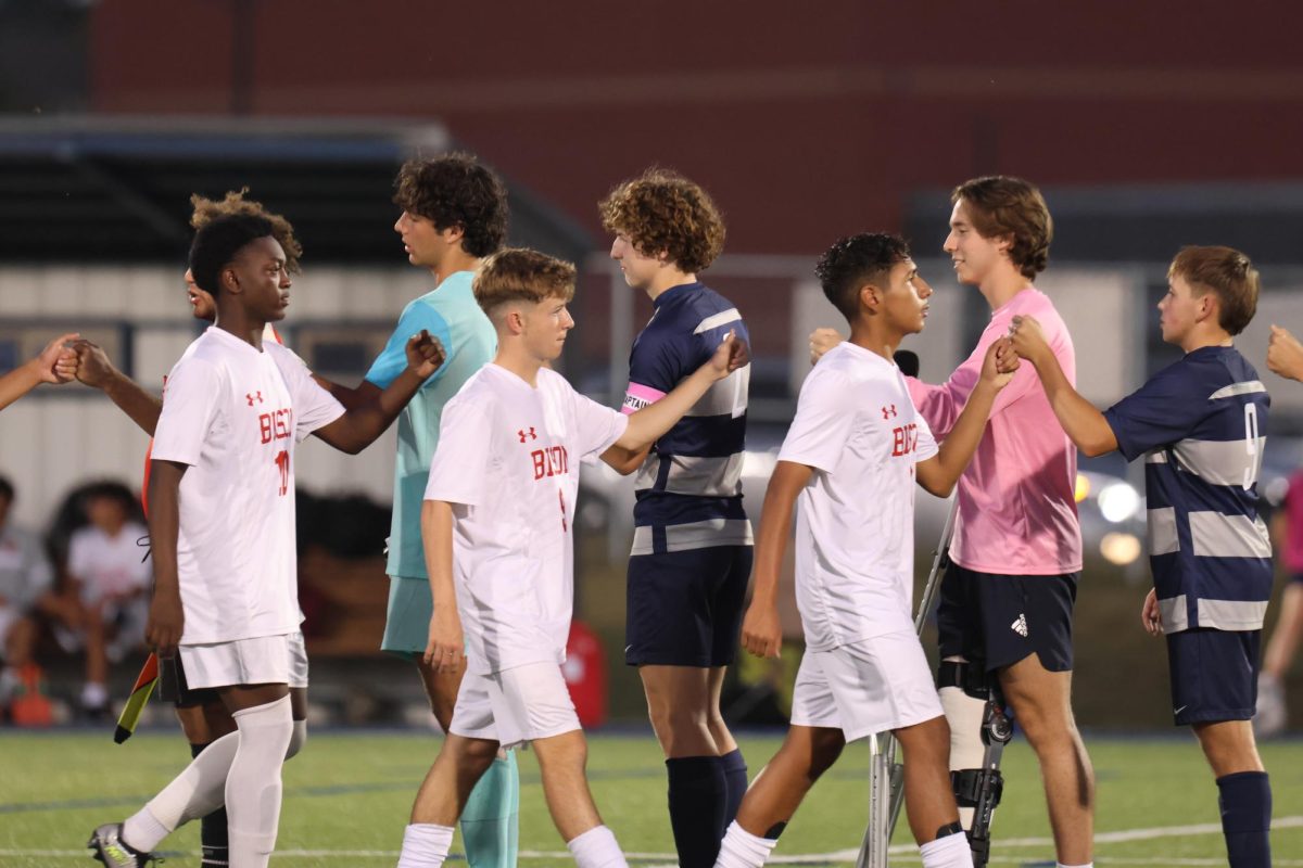 Before the game, the team fist bumps Shawnee Mission North before the game.