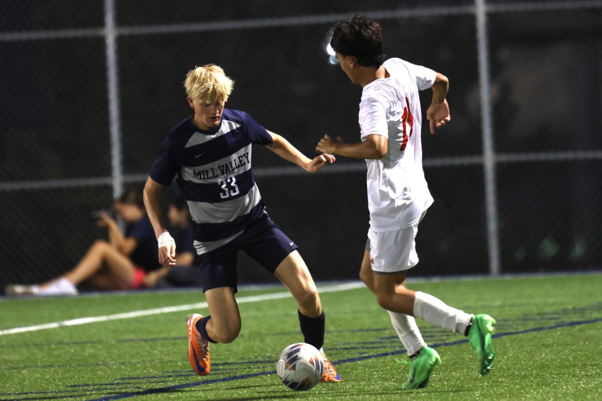 Keeping his distance, freshman Josiah Hayes fights to keep the ball from his opponent.