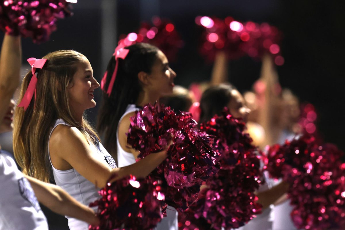 Facing the student section, junior Mallory Lux cheers during the game. 