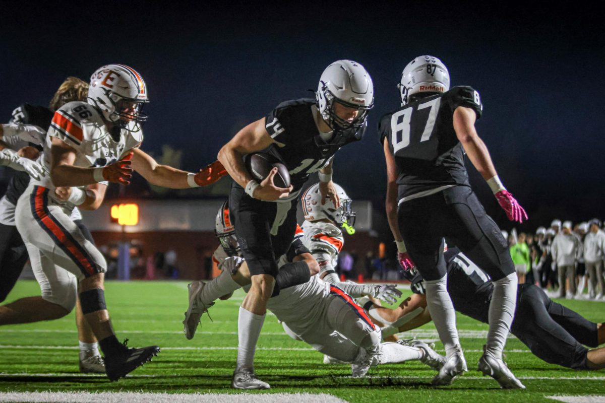 With a defender reaching for his leg, senior Connor Bohon runs into the endzone.