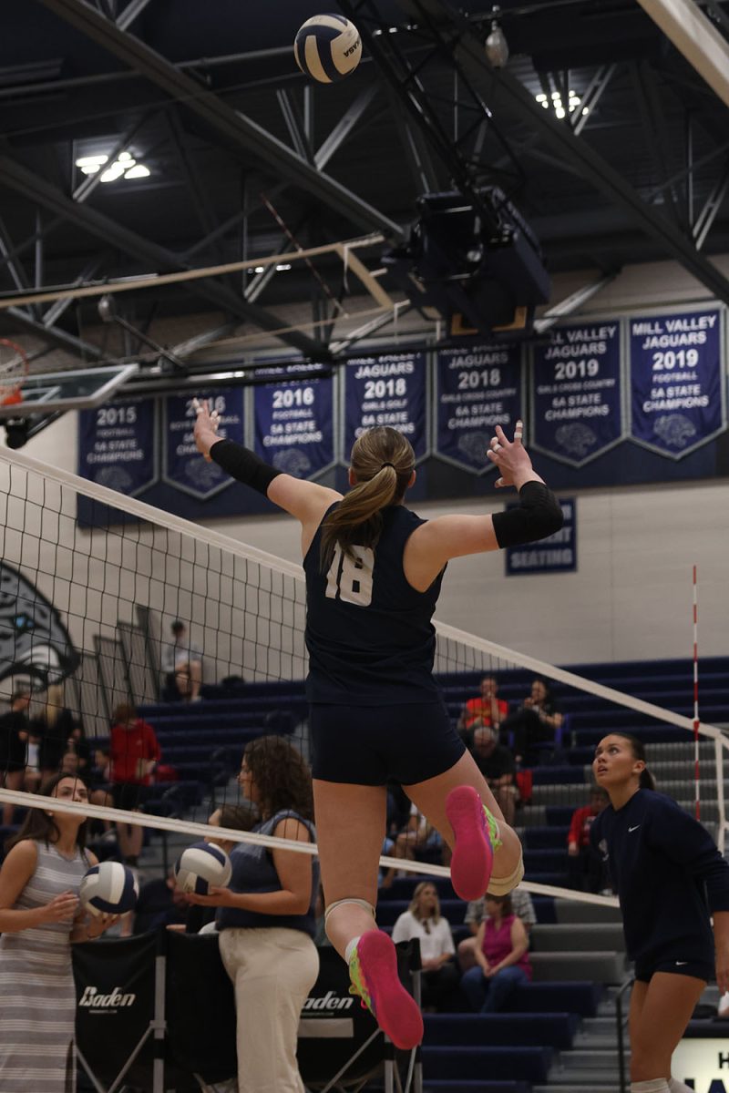 During pregame, sophomore Riley Riggs jumps up to hit the ball over the net.