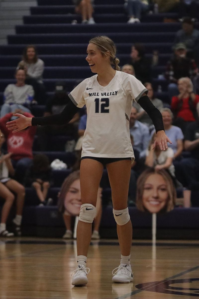 After getting a point, junior Corinne Schwindt smiles and goes to high-five her teammates Wednesday, Oct. 2.
