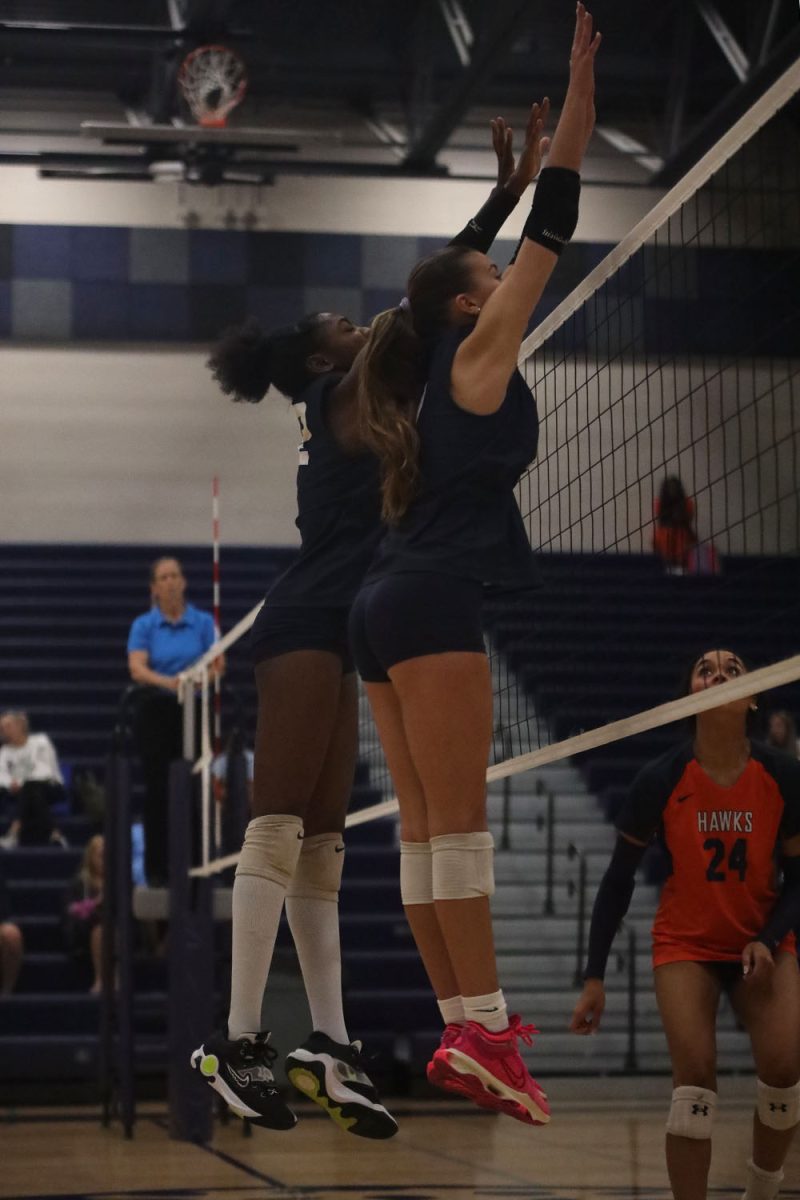 With their hands up, juniors Olivia Nzioki and Ella Florez block an attack Wednesday, Oct. 2.
