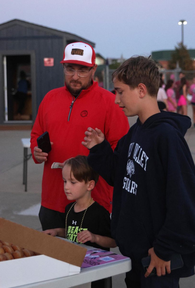 Deciding what donuts they want to buy, people of the community get ready to pay.