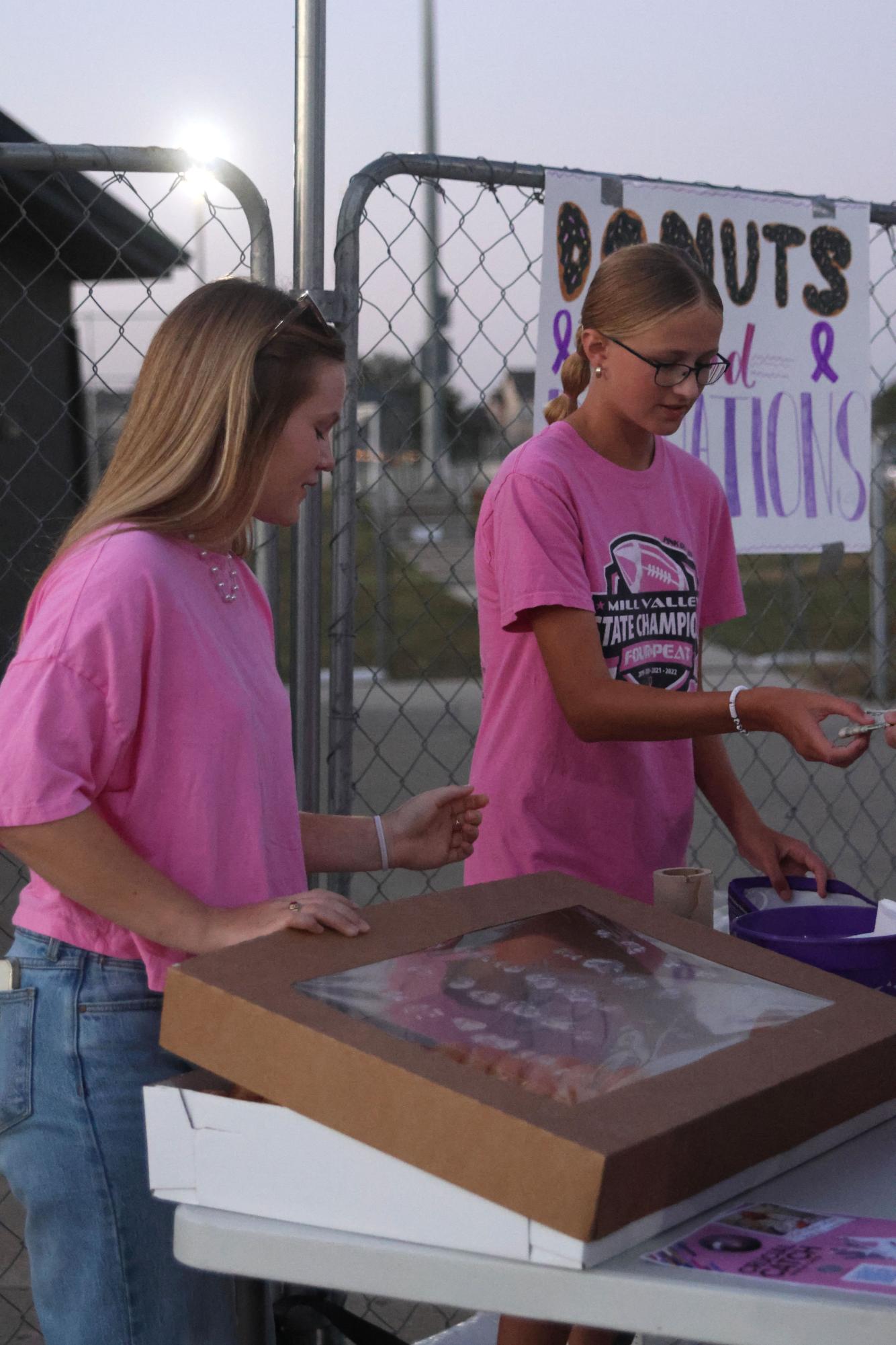 Selling donuts, freshmen Logan Stafford and Paige Lowe collect money.