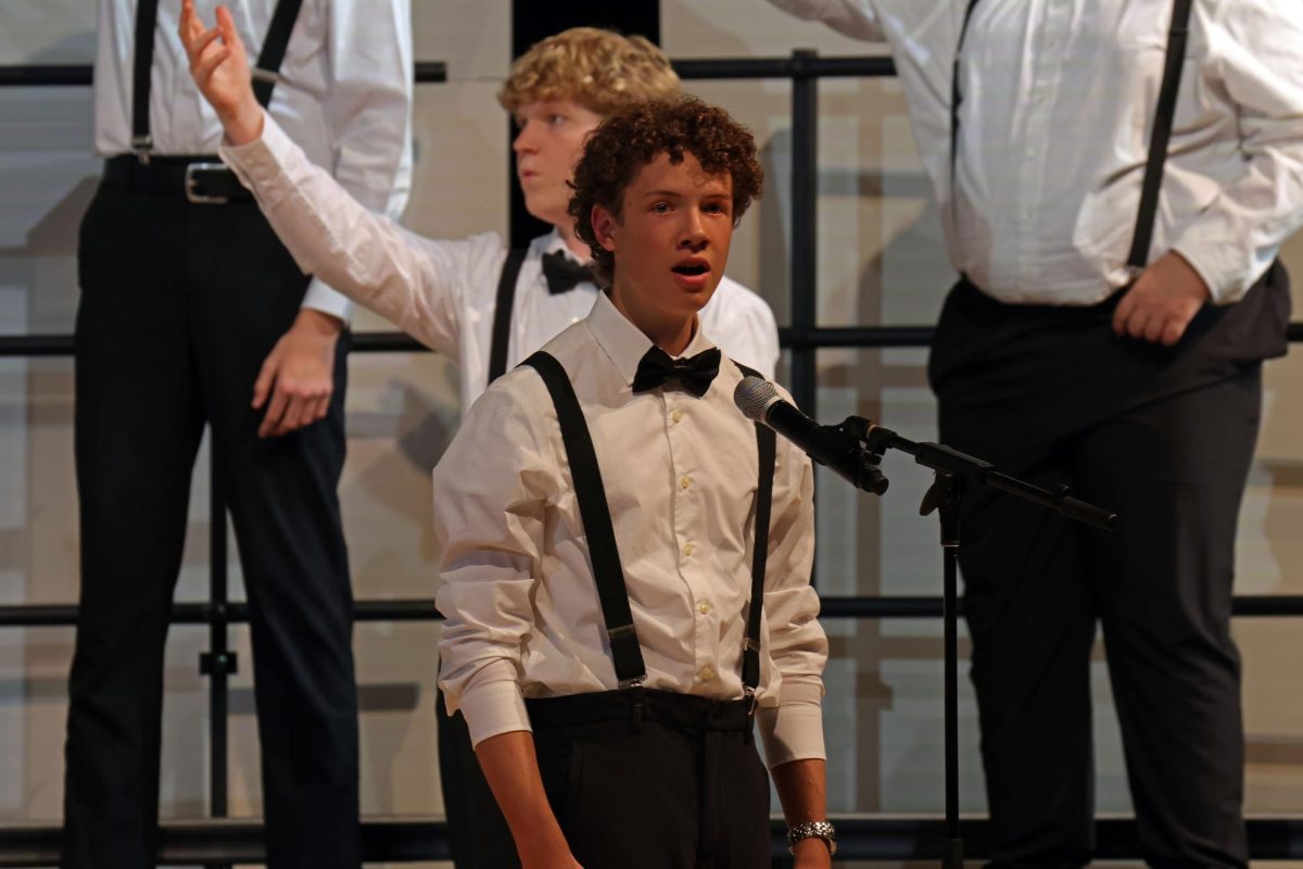 While the Tenor and Bass Choir dances behind him, sophomore Jack Niewohner sings his solo in “Goodnight, Sweetheart, Goodnight”.