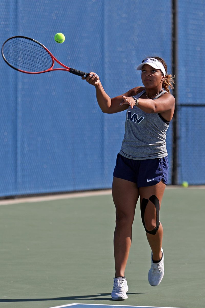 Looking up, senior Kyra Nelson hits the ball towards the other side of the court. 