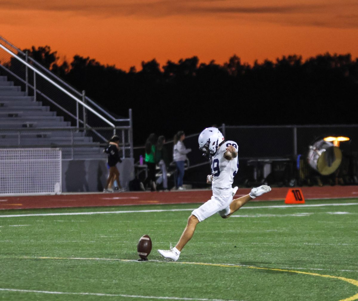 Senior Aidan Stanley kicks off under the sunset