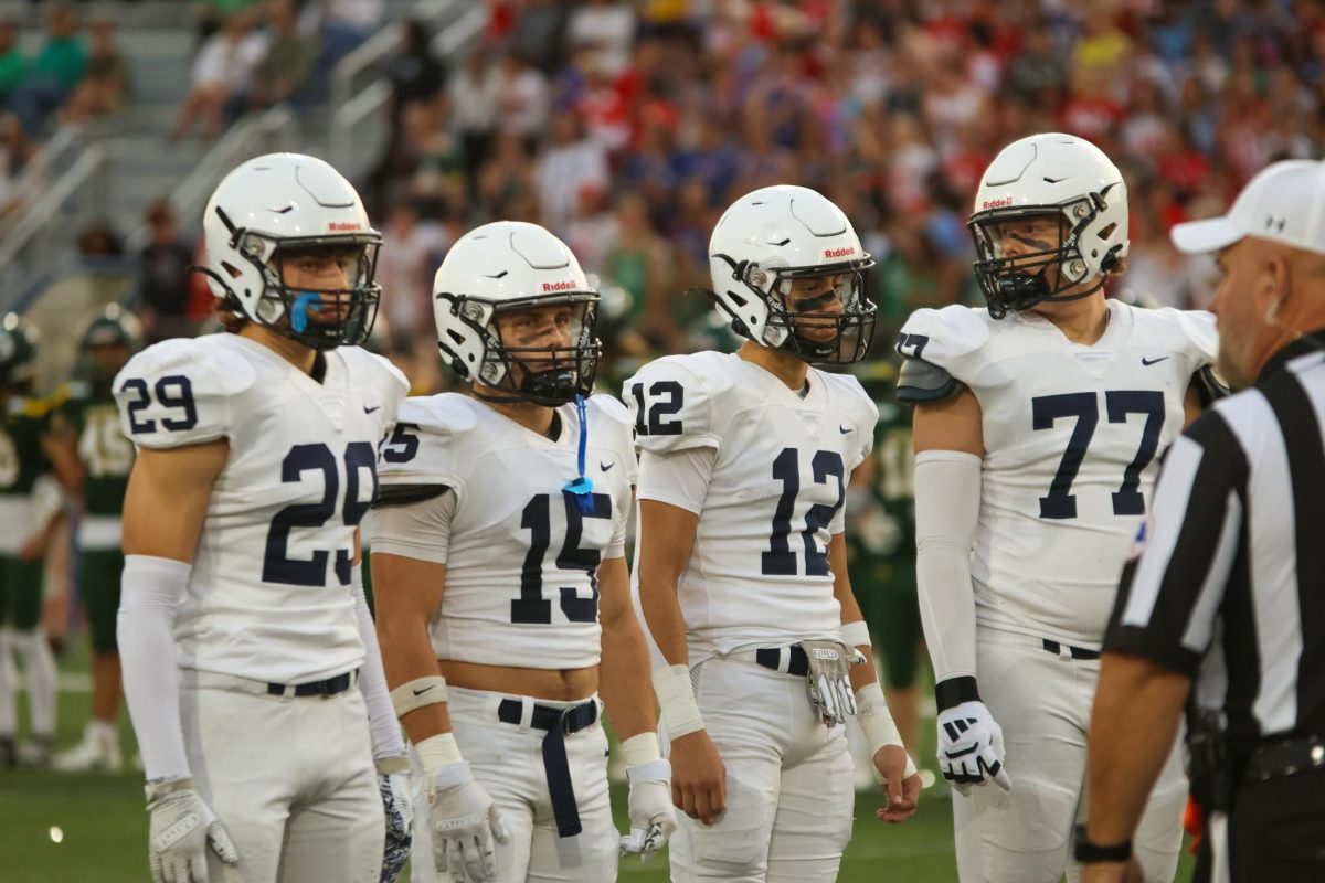 Captains Braden Peter, Andrew Watts, Blake Jay, and Aidan Lehr face off with Shawnee Mission south during the coin toss.