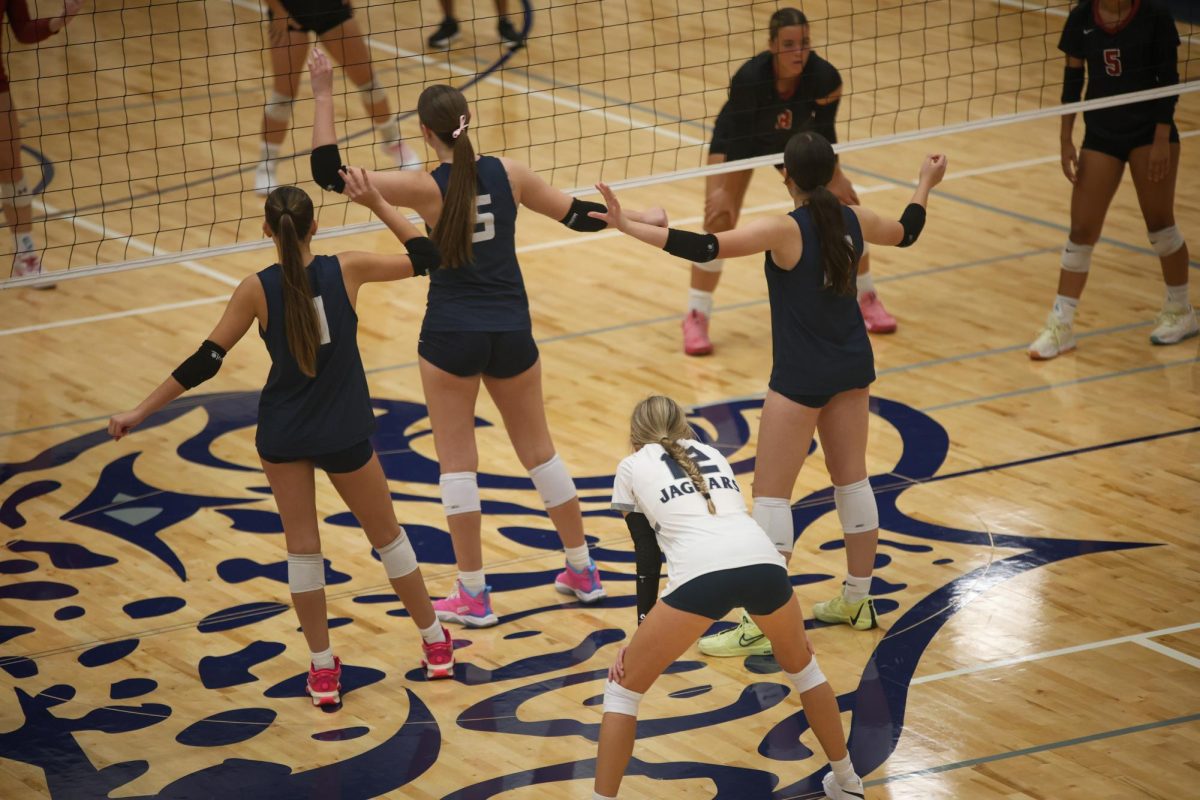 Senior Saida Jacobs, junior Ella Florez and freshman Sophia Sturdy all stand in front of Junior Corrine Schwindt as they prepare for the serve. 