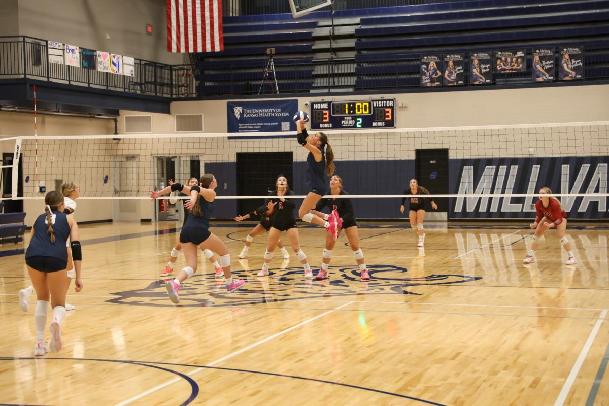 Junior Ella Florez jumps to set while senior Saida Jacobs prepares for the spike.