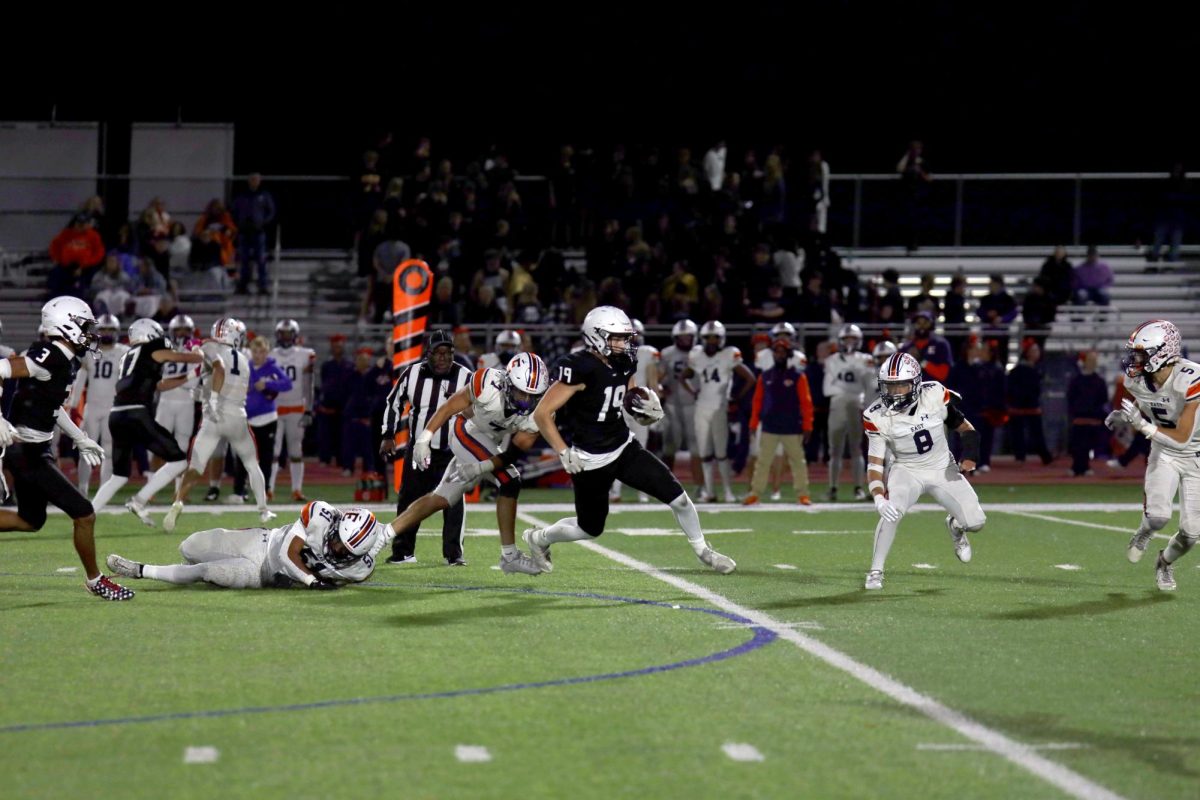 Sophomore Max Piva runs past the defensive line to score a touchdown.