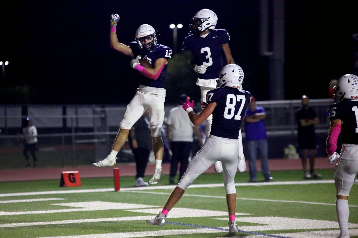 Junior Blake Jay celebrates with seniors Desmon Williams and Isaac Sauder after making a touchdown.