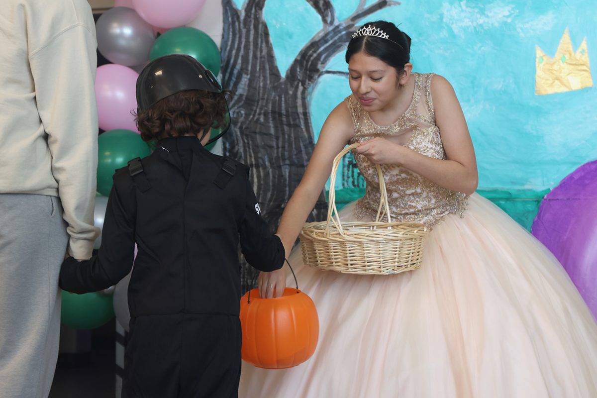 In a princess dress, sophomore Natalia Castillejos-Ramírez welcomes kids with candy.