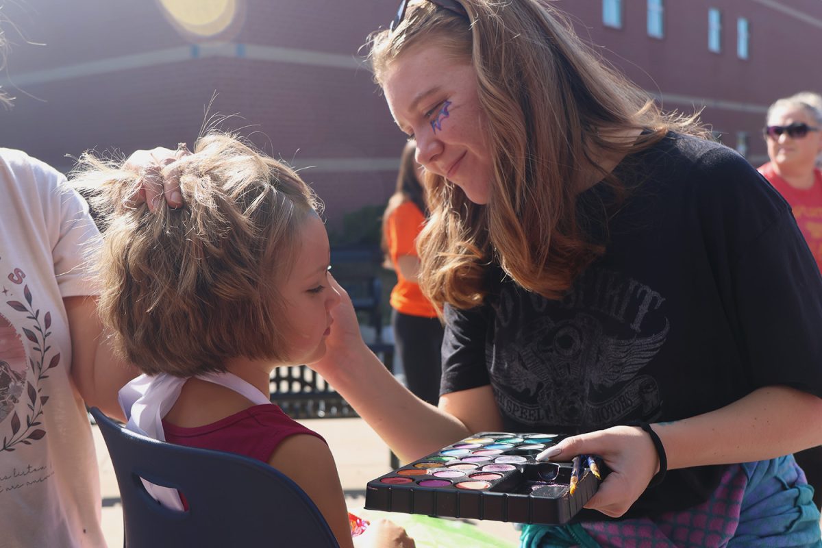 Junior Taylor Goodwin does face painting at Haunted Halls.