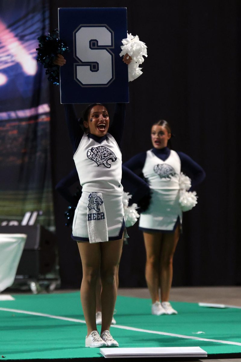 Holding up an “S,” senior Jada Winfrey leads a chant.