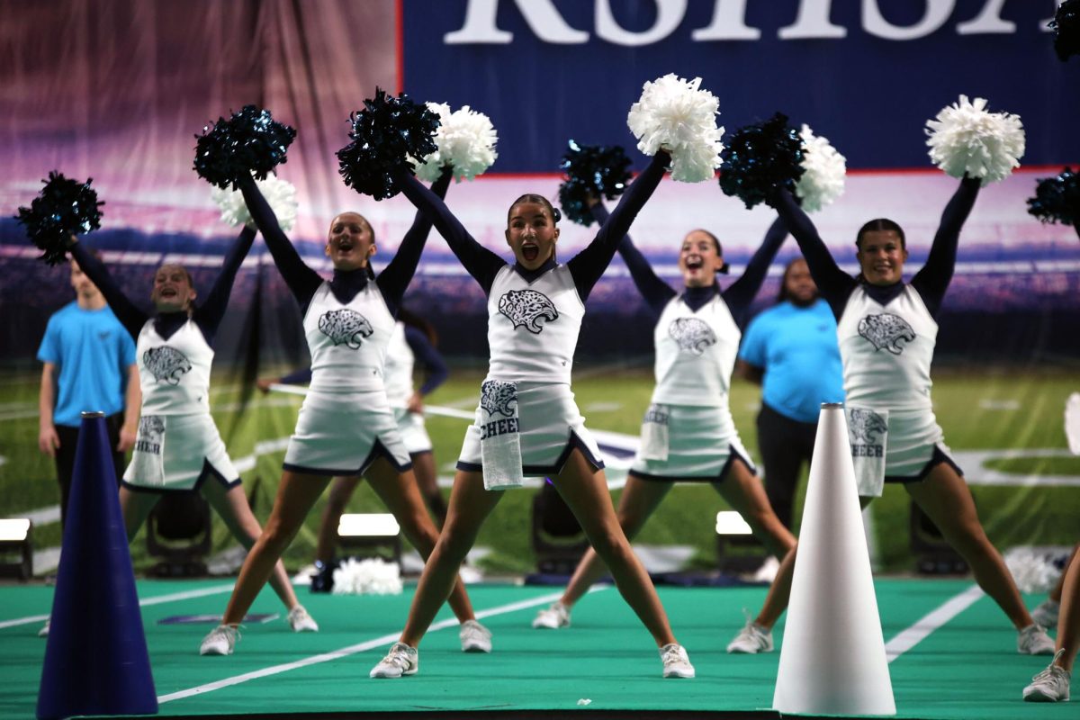 Cheering loudly, junior Sydney Epperson performs the fight song.