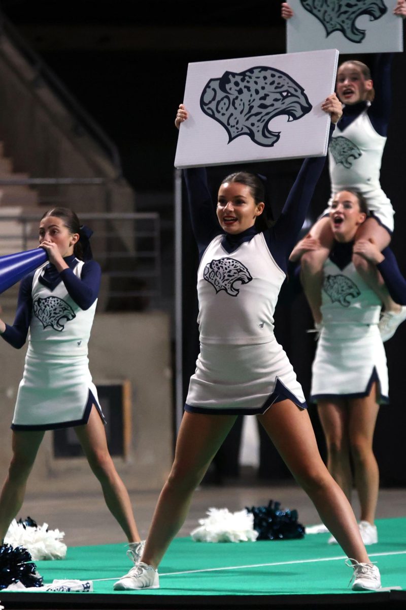 With a smile, senior Rylie Maguire holds up a jaguar sign.