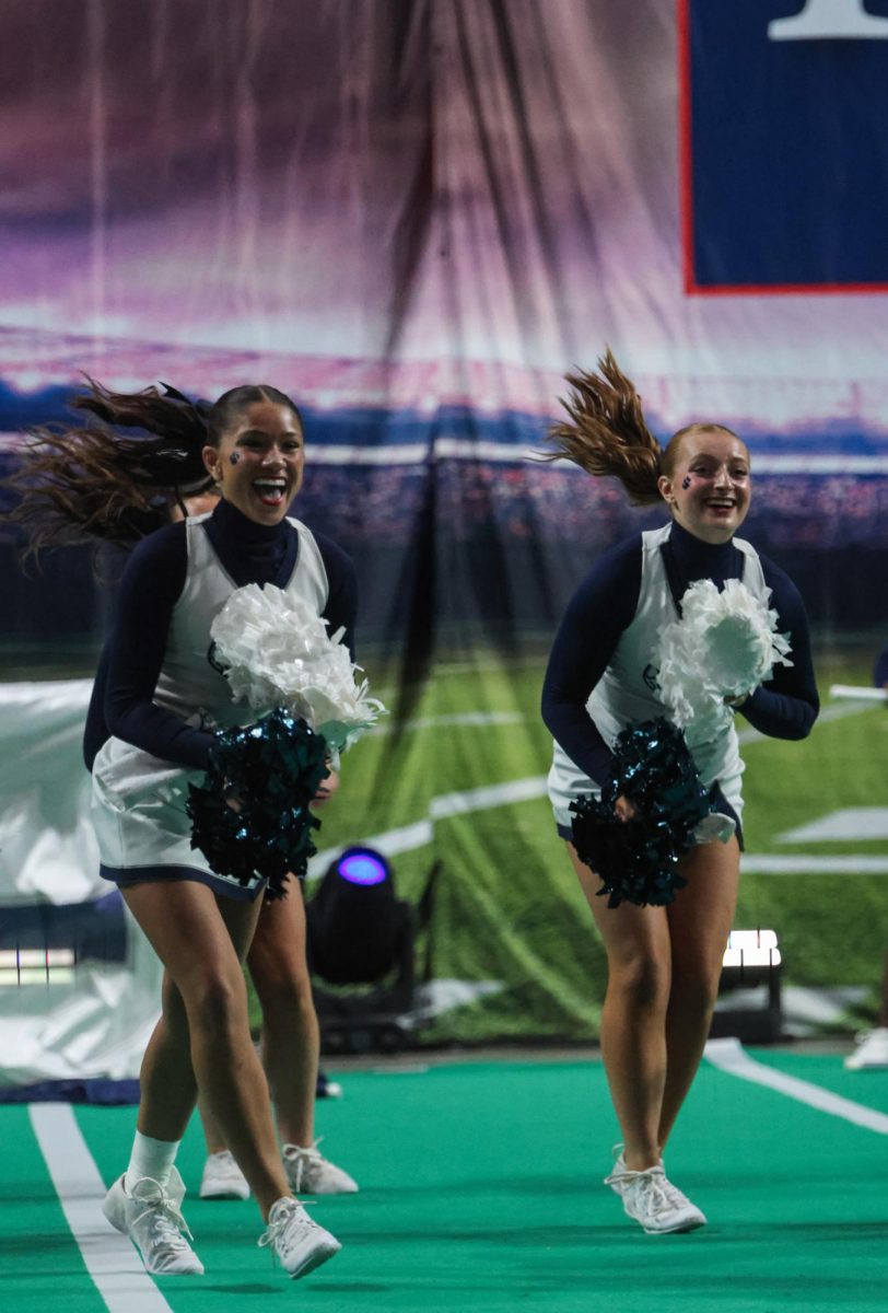 Moving positions, sophomore Amanda Makalous and senior Emersyn Jones smile at the crowd.
