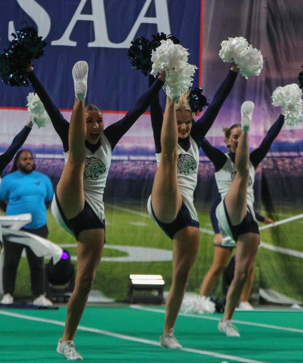 With power, junior Brynlee Sword and junior Sydney Epperson high kick in unison.
