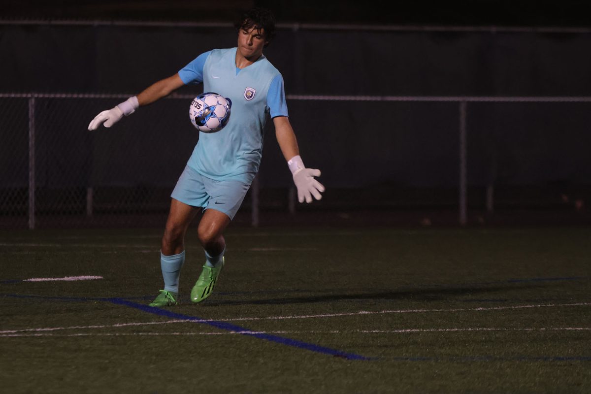 Dropping the ball, senior Alex Grace gets ready to kick the ball to a teammate.