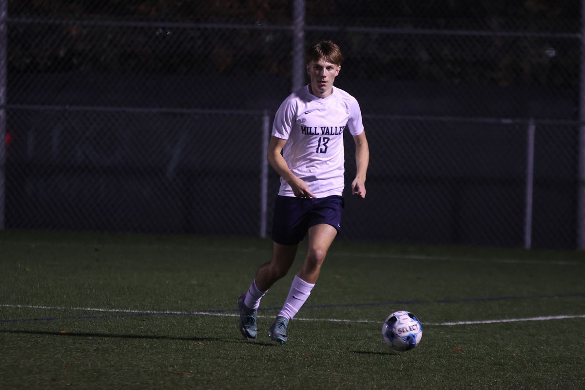 Looking for and open teammate, senior Drew Enloe prepares himself to kick the ball.