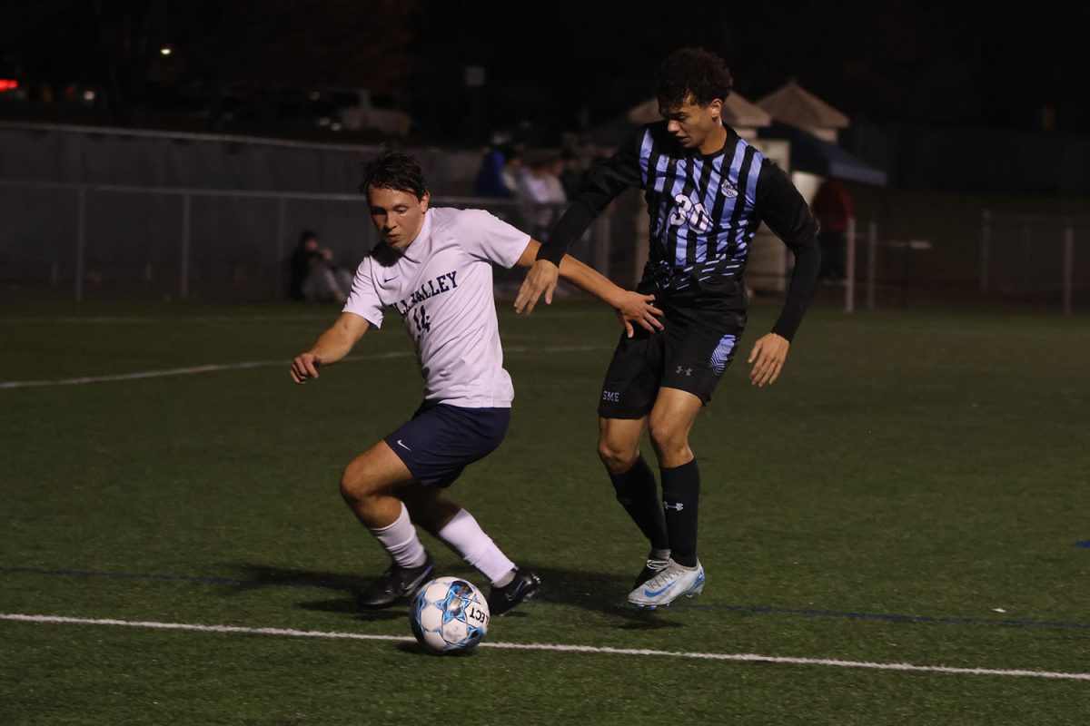 Focused on the ball, senior Kai Burford tries to move around his defender with the ball.