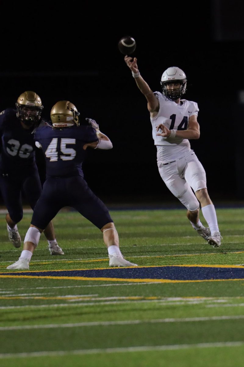 Avoiding the opponent, senior Connor Bohon throws the ball.