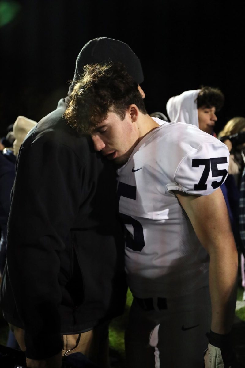 After the emotional loss, senior Alex Buckmaster hugs a family member.