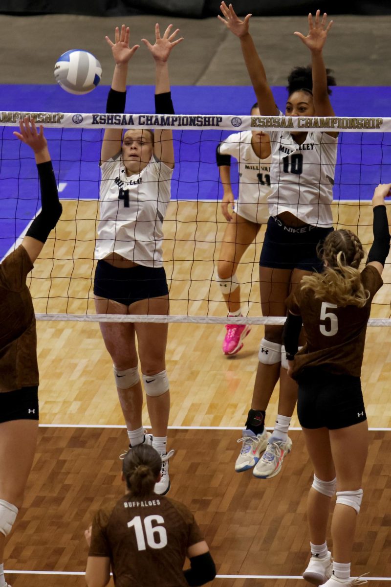 In sync, senior Brekhan Waters and junior Leilah Perry block the ball against Garden City.