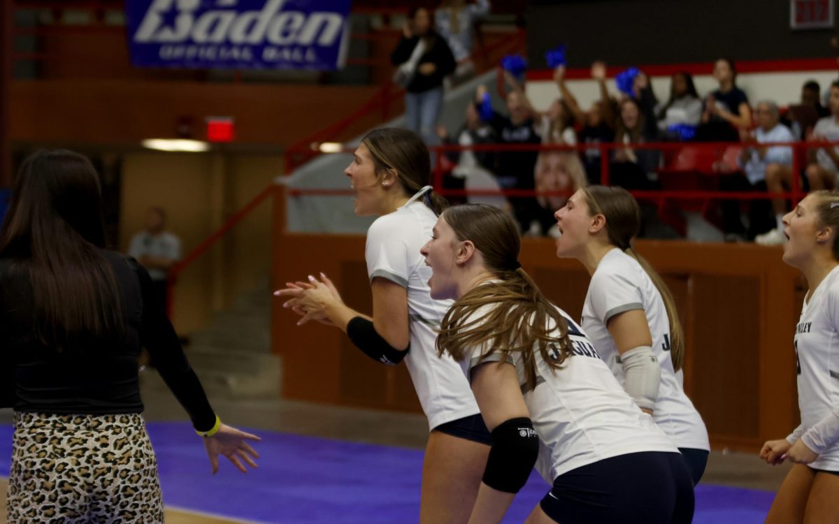 Clapping, seniors Saida Jacobs and Ashlyn Blazer cheer in celebration against Olathe West. 