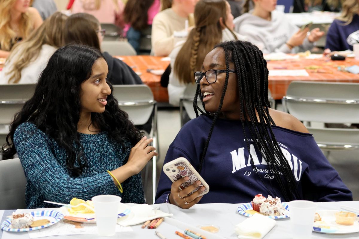 Juniors Rachel Johnson and Doreen Mahugu debate on which answer they should choose in the Thanksgiving Themed Kahoot. 