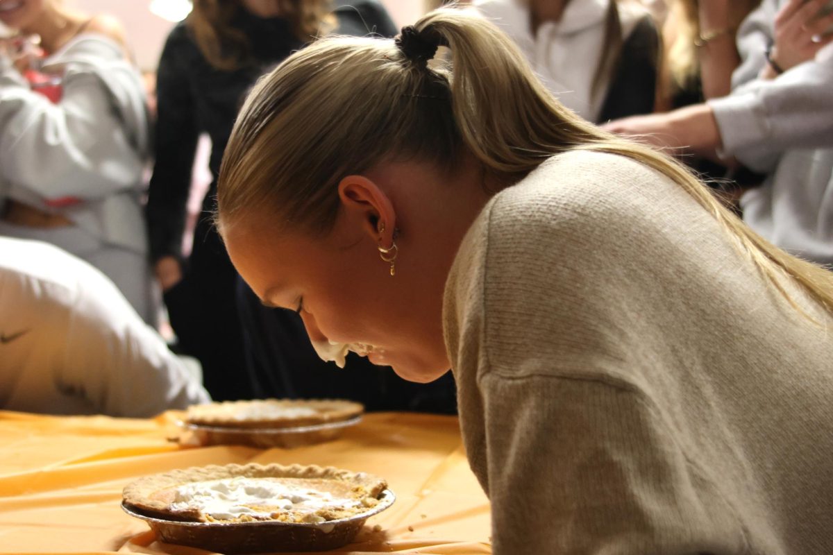 Sophomore Avery Huber participates in a pie eating contest, eating as fast as she can to beat the other contestants.