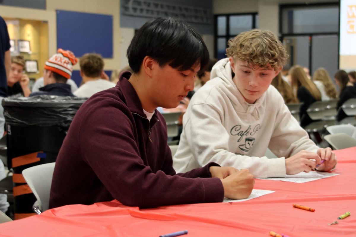 Juniors Noah Kim and Jack Daly sit down to color a thanksgiving turkey, patiently awaiting for all of the guests to arrive in time for dinner.