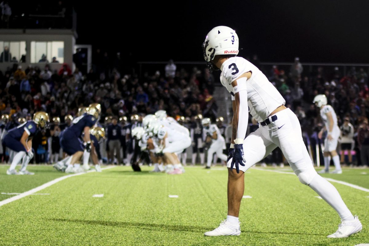 With a close eye, senior Desmon Williams watches his team as he waits for the play to begin.