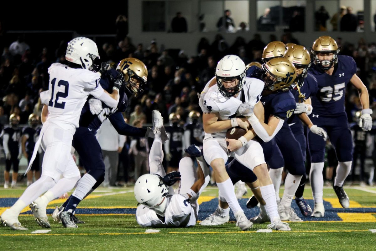 Ball in hand, senior Connor Bohon runs through the field. 