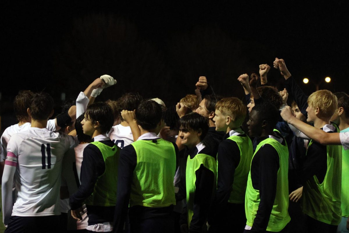 Team finishes their final pre game pep talk with a cheer. 