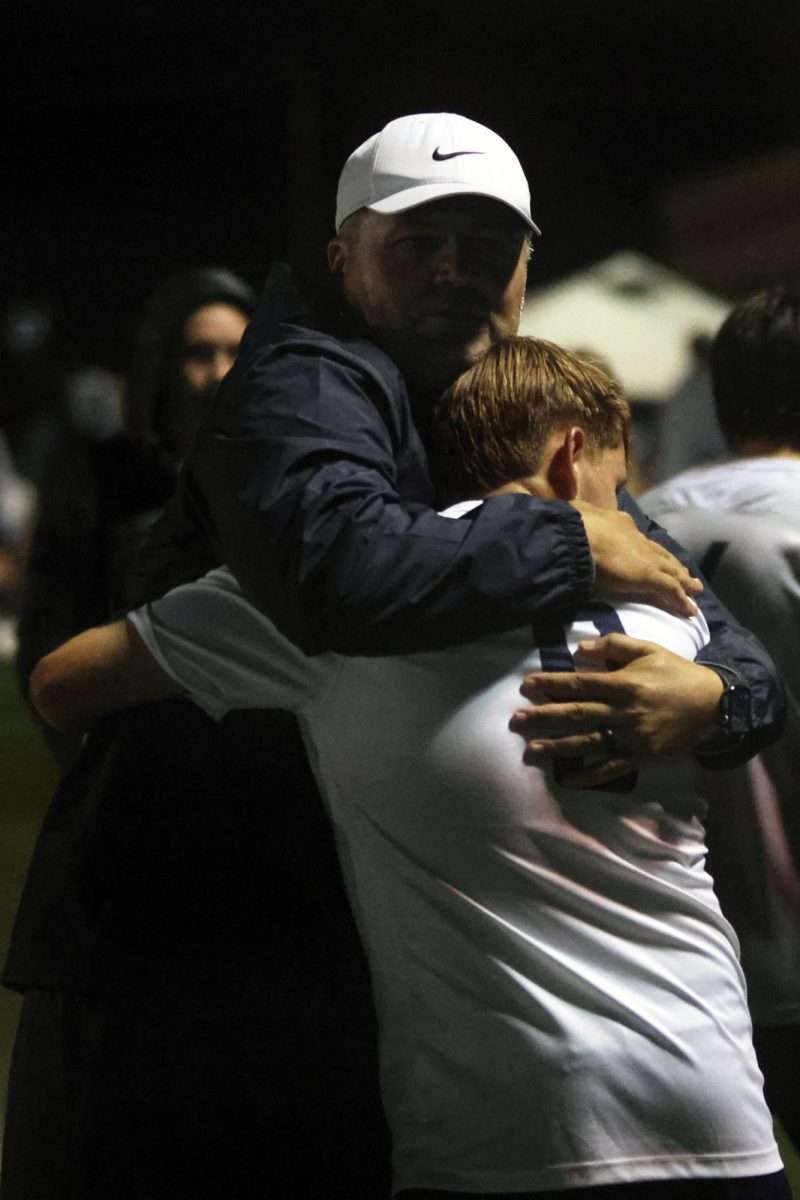 Senior Carter Coup hugs a coach after a loss to end his high school soccer career.  