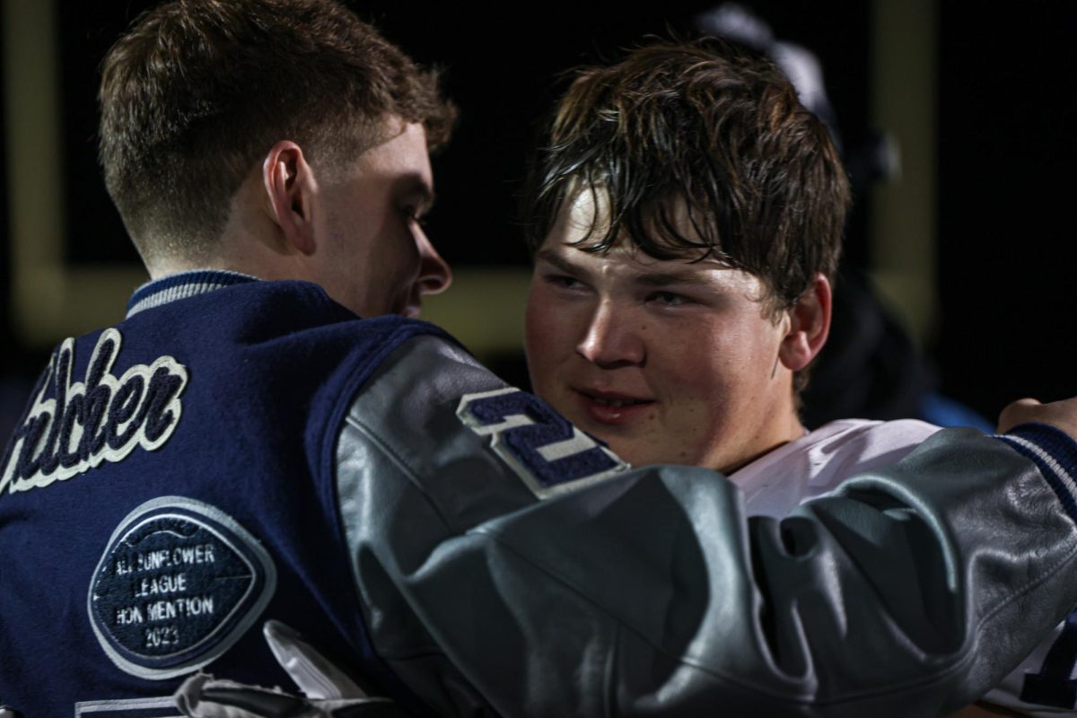 With red eyes, senior Eric Penner talks with former football player and Mill Valley alum Jack Fulcher. 